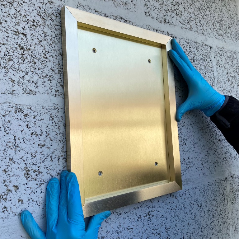 Porte-menu ext&eacute;rieur en laiton fix&eacute; sur fa&ccedil;ade de restaurant